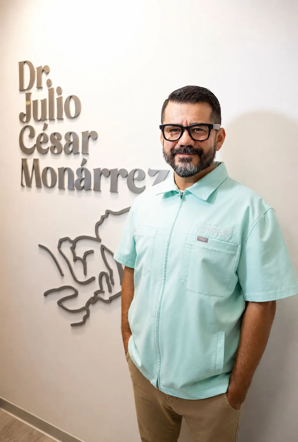 El Dr. Julio César Monárrez frente al letrero de su consultorio